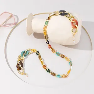 Dettaglio catena per occhiali con anelli in resina colorata e maglie in metallo dorato