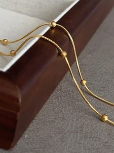 Detailed macro view of 18k gold plated snake chain necklace with small beads