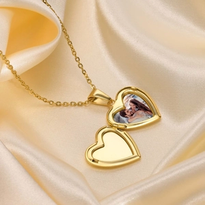 Detailed close-up of a heart locket necklace in gold finish with a photo feature