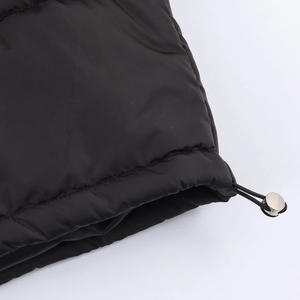 Women's black oversized puffer jacket featuring a functional drawstring hem with silver toggle