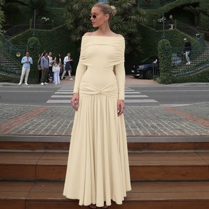 Detailed view of the off-shoulder neckline and pleated waist of the beige maxi dress