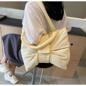 Vue détaillée d'un sac cabas surdimensionné avec nœud jaune clair en tissu texturé