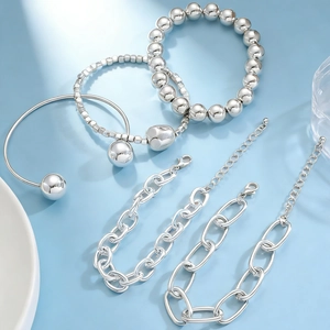 Detailed view of silver-toned metal bracelet set featuring beads and minimalist bangles