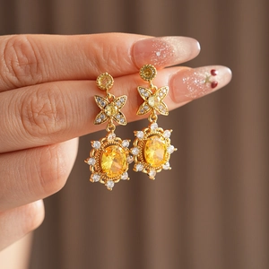 Detailaufnahme von Vintage Blumenohrringen in Gold mit gelbem ovalem Zirkoniastein