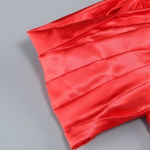 Detailed view of red satin fabric with elegant pleated texture for an evening dress