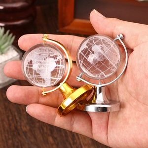 Close-up of mini crystal globes with gold and silver metal bases held in hand