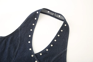 Detailed view of dark blue denim halter top with silver rivet studs along the neckline