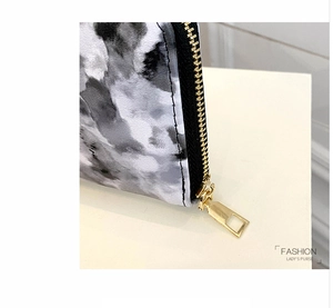 Detail of grey marble pattern long wallet featuring a high-quality gold zipper and square puller