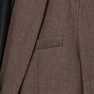 Détail du revers et de la poche sur un blazer tissé marron texturé pour femmes