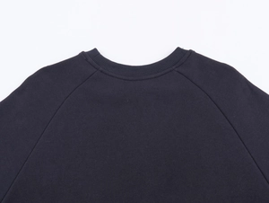 Close-up of crew neck sweatshirt showing raglan sleeves and ribbed knit collar detail