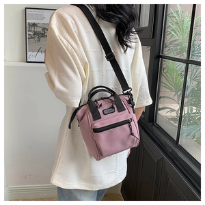 Photo de sac à bandoulière en nylon rose avec sangles noires et détail du logo sport