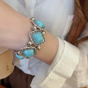 Vintage silver metal bracelet featuring turquoise stones with embossed floral details