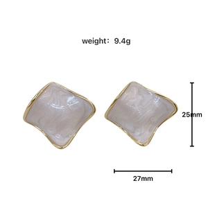 Detailed view of geometric gold earrings with marble enamel inlay and size measurements