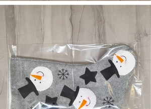 Detailed view of gray Christmas stocking with snowman and star patterns in packaging