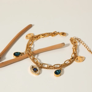 Gold double-layer evil eye bracelet with blue crystals and bohemian charms