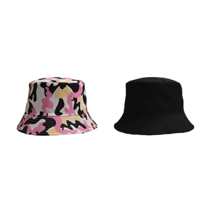 Flat lay of pink camouflage and solid black cotton bucket hats with stitching details