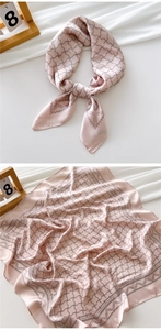 Detail of pink silk scarf with grey geometric pattern and elegant knotted texture