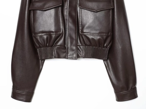Close-up of deep brown faux leather jacket featuring flap pockets and buckled cuffs