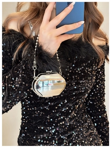 Silver octagonal mirror mini bag with thin metal chain strap shown in a social style