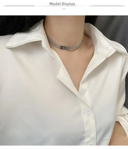 Détail du collier ras de cou en maille argentée avec lettrage Good Luck sur mannequin