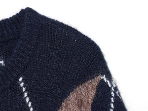 Close-up of diamond pattern knit sweater with navy, brown and white mohair fibers