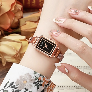 Close-up of a vintage square women's quartz watch with rose gold mesh band on a wrist