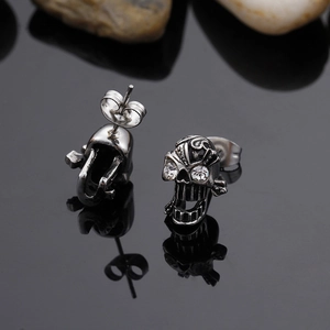 Gothic style skull stud earrings in vintage silver with crystals and mirror reflection