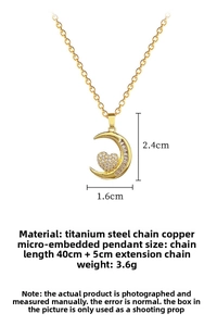 Dettaglio macro della collana con ciondolo a luna e cuore dorato con cristalli luminosi