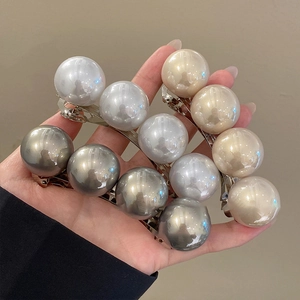 Detailed view of handmade pearl hair clips in white, beige, and grey with silver alloy base
