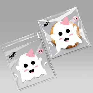 Close-up of Halloween treat bags with white ghost patterns and pink hearts for party cookies
