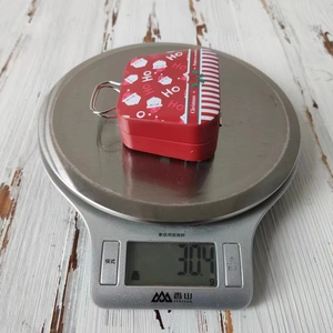 Christmas tinplate candy box weight measurement of 30.4g on a digital kitchen scale