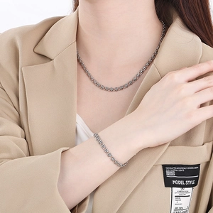 Détail de l'ensemble collier et bracelet en acier inoxydable de style industriel sur mannequin