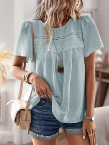 Close-up of light blue top with hollow lace and polka dot jacquard texture details