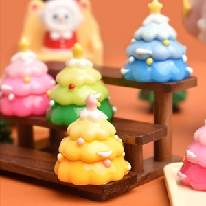Macro shot of mini resin Christmas trees in yellow, green, pink and blue for DIY crafts