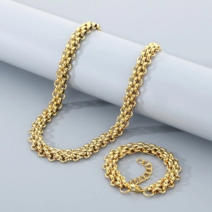 Close-up of golden braided stainless steel necklace and bracelet set on a display stand