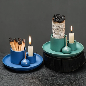 Morandi blue ceramic candle holder set with sage and palo santo on a dark textured surface