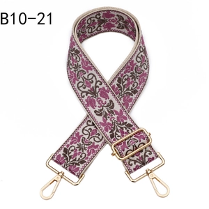 Close-up of colorful ethnic jacquard purse strap with floral embroidery and gold hardware