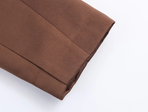Vue détaillée du satin marron foncé montrant les coutures précises et la texture lisse