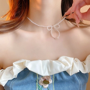 Sweet faux pearl and crystal woven bowknot choker necklace for women on a model