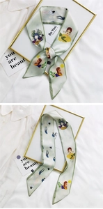 Detail of light green silk scarf featuring girl illustration pattern and elegant bow knot