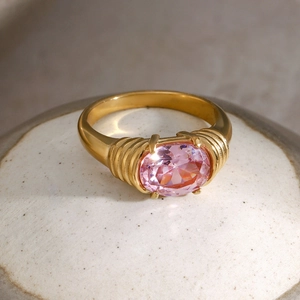 Macro detail of 18k gold plated ring featuring an oval pink gemstone and ribbed texture