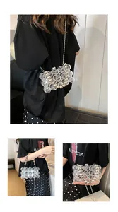 Detail view of clear acrylic bubble bag with golden pearl handle and metal chain strap