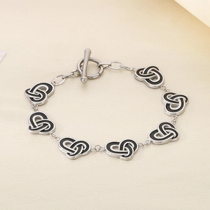 Detail of silver chain bracelet with black enamel heart knots and a classic OT toggle clasp