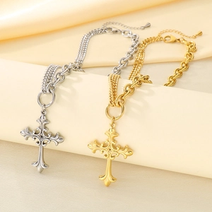 Detail of gold and silver layered cross necklaces on beige silk background