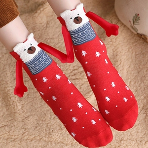 Detailed close-up of red Christmas socks with cartoon bear and magnet hand feature