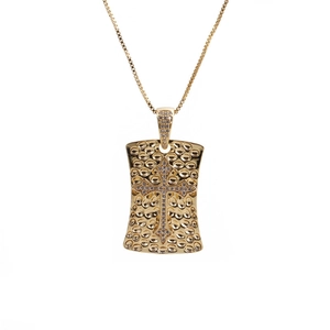 Close-up of golden hammered dog tag pendant with zircon cross and elegant box chain