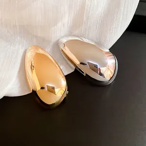Minimalist irregular metal brooches in gold and silver with a polished mirror finish