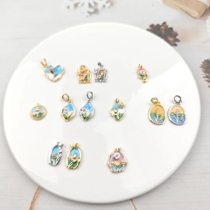 Vintage oil painting style enamel pendants with gold and silver frames in a ceramic tray