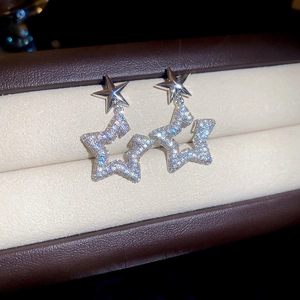 Macro shot of double star earrings with silver finish and sparkling zircon stones