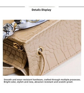 Détails de la texture crocodile beige avec fermeture éclair dorée et poignée en foulard de soie
